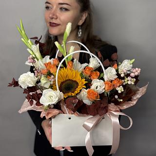 Букет из белых гладиолусов, подсолнуха, кустовых роз и декоративных ягод в сумочке