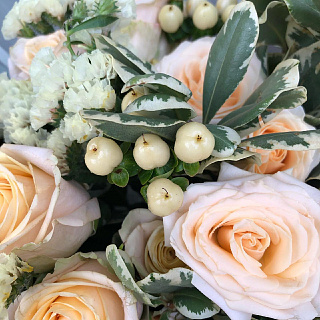 Букет из персиковых кустовых роз, гиперикума, старицы и декоративной зелени