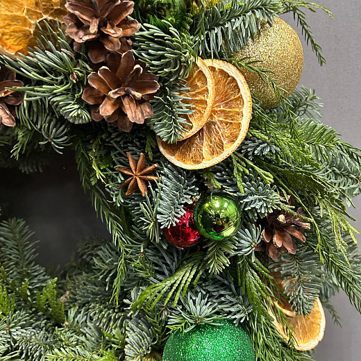 Новогодний венок с разноцветным декором и Щелкунчиком по лучшей цене в Москве Новогодний венок с разноцветным декором и Щелкунчиком с доставкой в Москве